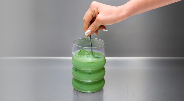 step 5: stirring an iced matcha latte to fully combine matcha, milk, and ice